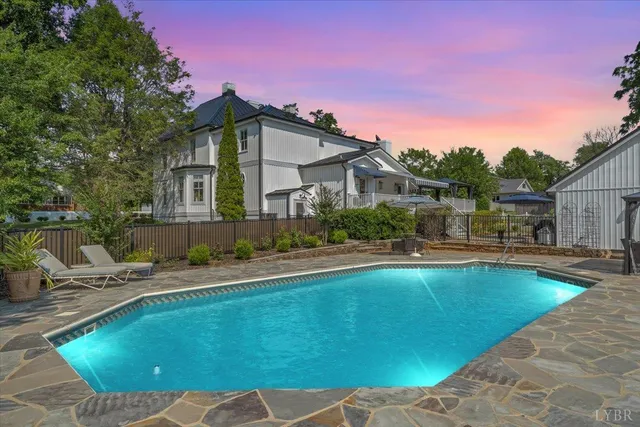 a view of a house with pool lawn chairs and a fire pit