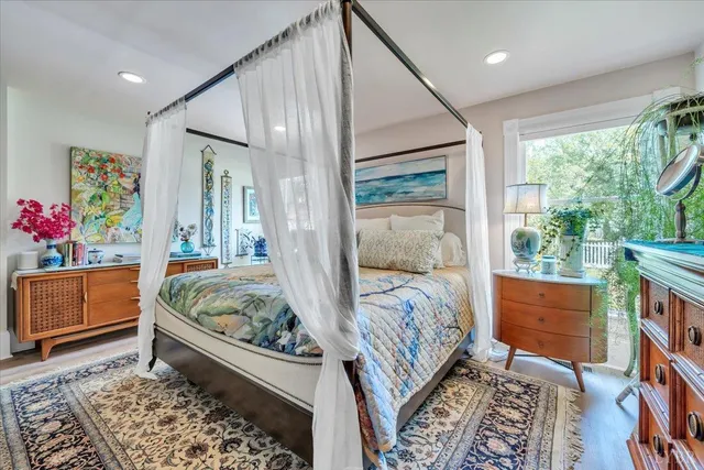 a view of a patio with couches and table and chairs with wooden floor and fence