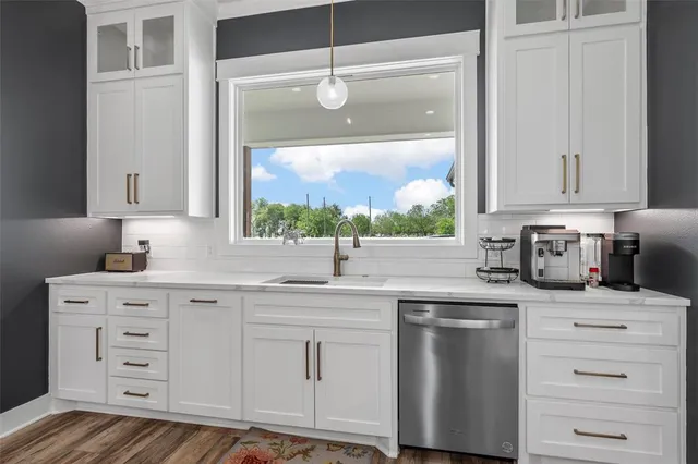 a kitchen with cabinets appliances a sink and a window