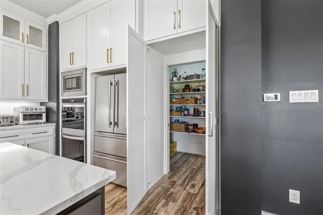 a kitchen with stainless steel appliances a refrigerator and a stove top oven