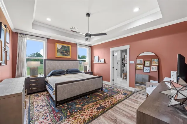 a bedroom with a bed wooden floor and window