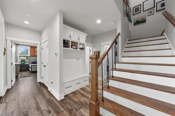 a view of hallway with stairs and wooden floor