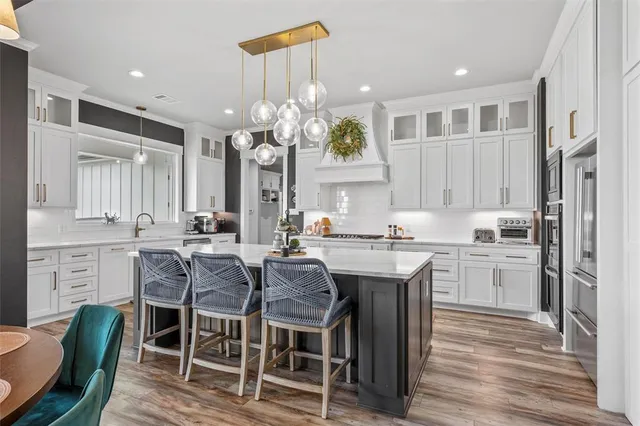 a kitchen with kitchen island granite countertop a sink cabinets and wooden floor