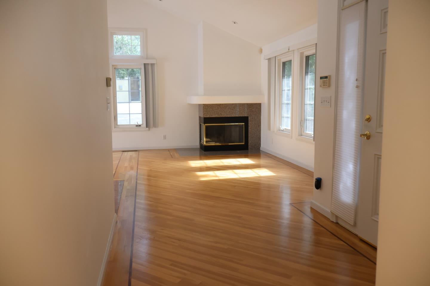2360 Woodside Road, Unit A Woodside, CA 94062 - Photo 17 of 27 a view of a livingroom with wooden floor a fireplace and windows