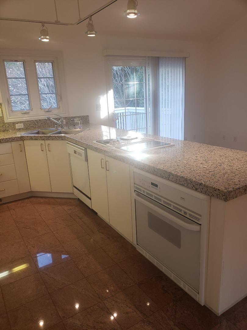 2360 Woodside Road, Unit A Woodside, CA 94062 - Photo 26 of 27 a kitchen with granite countertop white cabinets and white appliances
