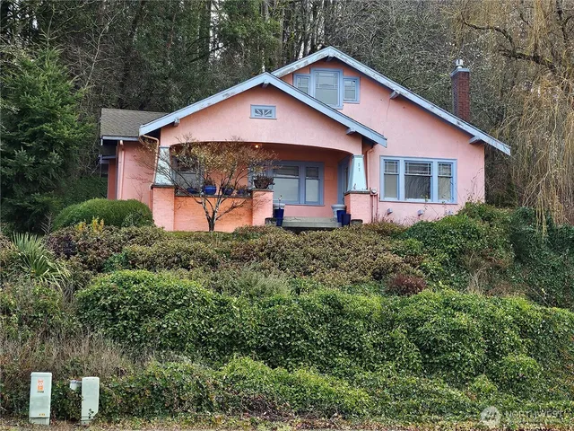 a front view of a house with a yard and trees
