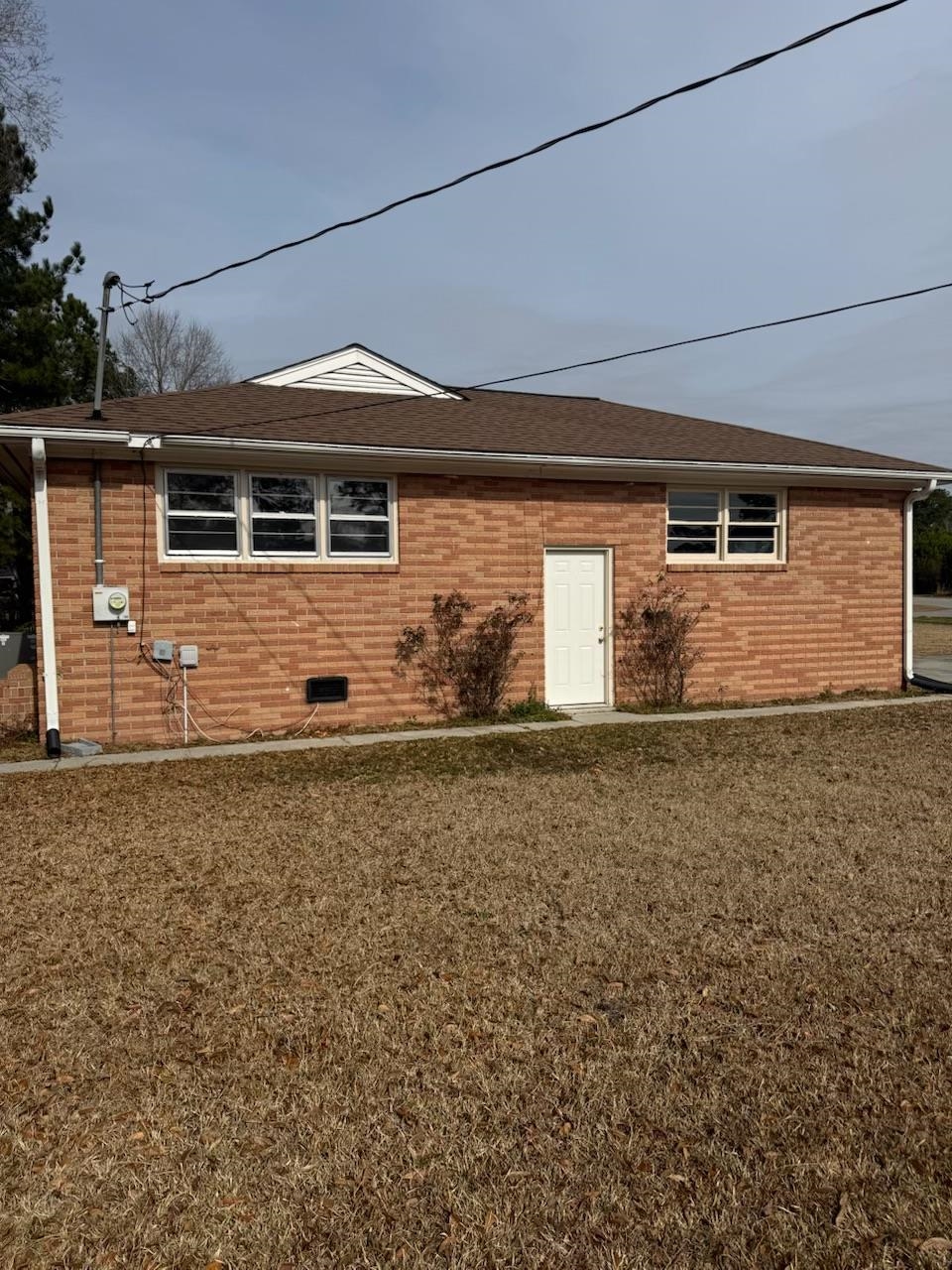 4625 Graham Street Loris, SC 29569 - Photo 2 of 11 Rear view of house featuring brick siding, a lawn, a shingled roof, and crawl space