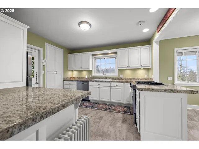 a kitchen with granite countertop a sink stove and cabinets