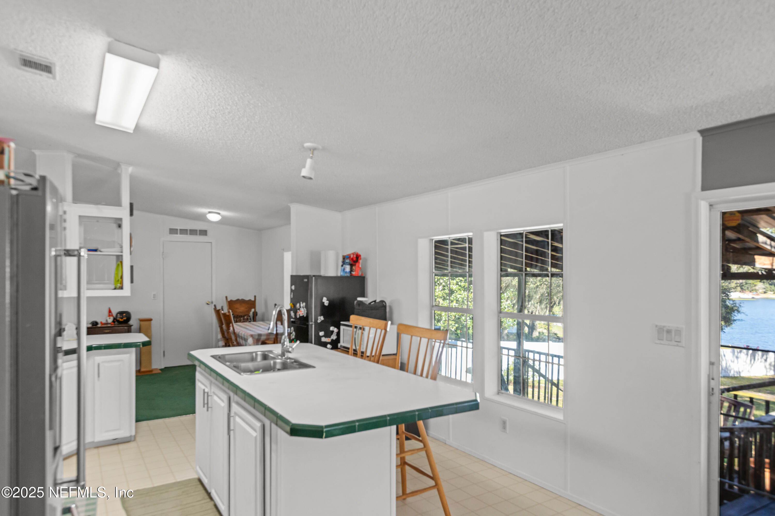 6279 Little Lake Geneva Road Keystone Heights, FL 32656 - Photo 16 of 45 a kitchen with kitchen island a stove a refrigerator a sink dishwasher with a dining table and chairs
