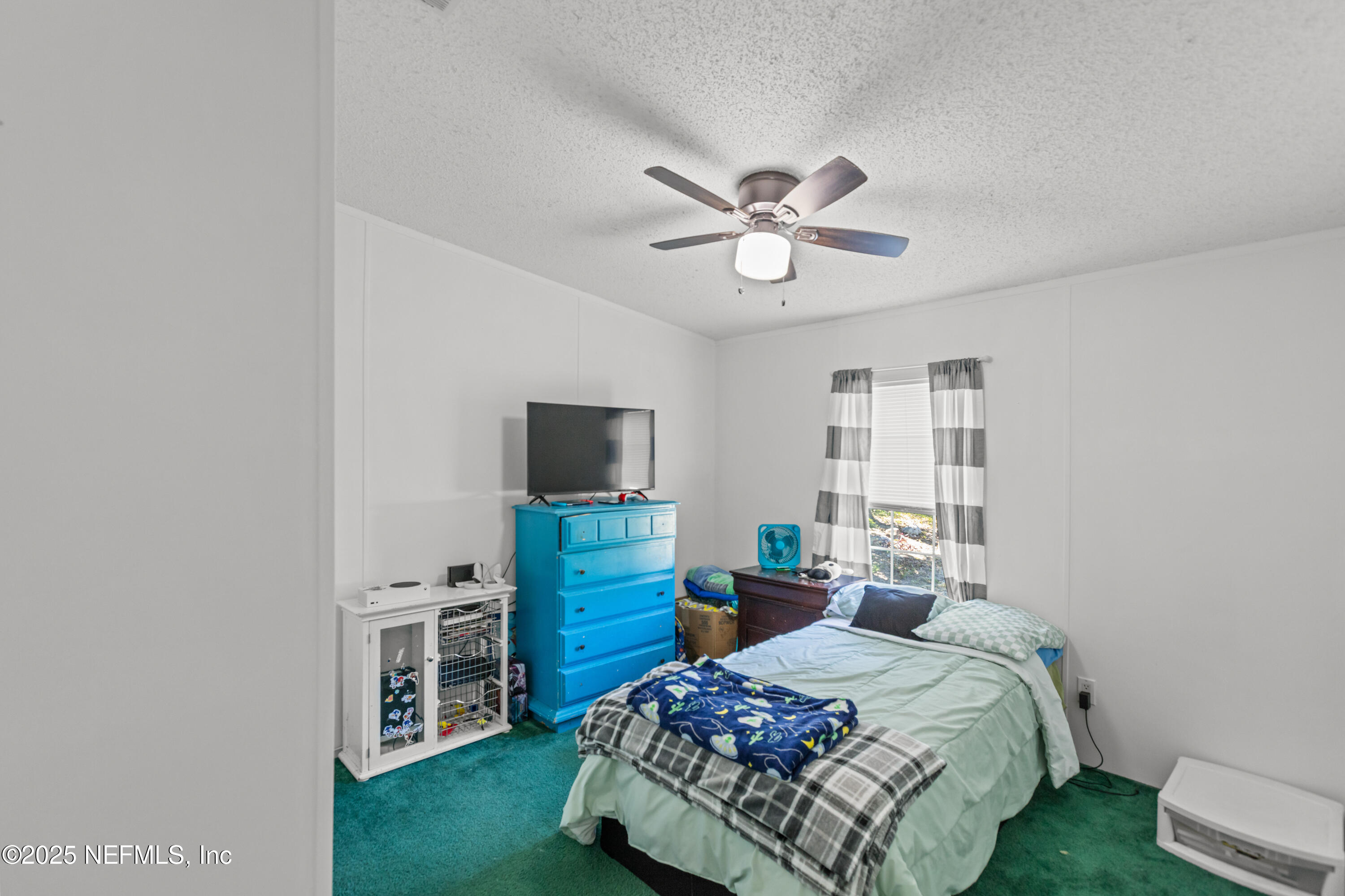 6279 Little Lake Geneva Road Keystone Heights, FL 32656 - Photo 26 of 45 a bedroom with a bed a chandelier and a television