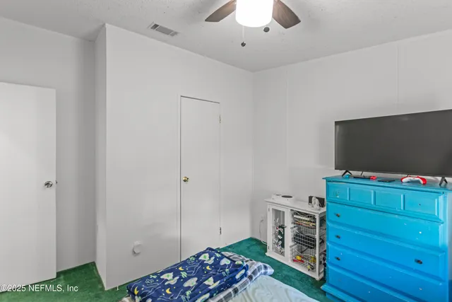 a bedroom with a bed and flat screen tv