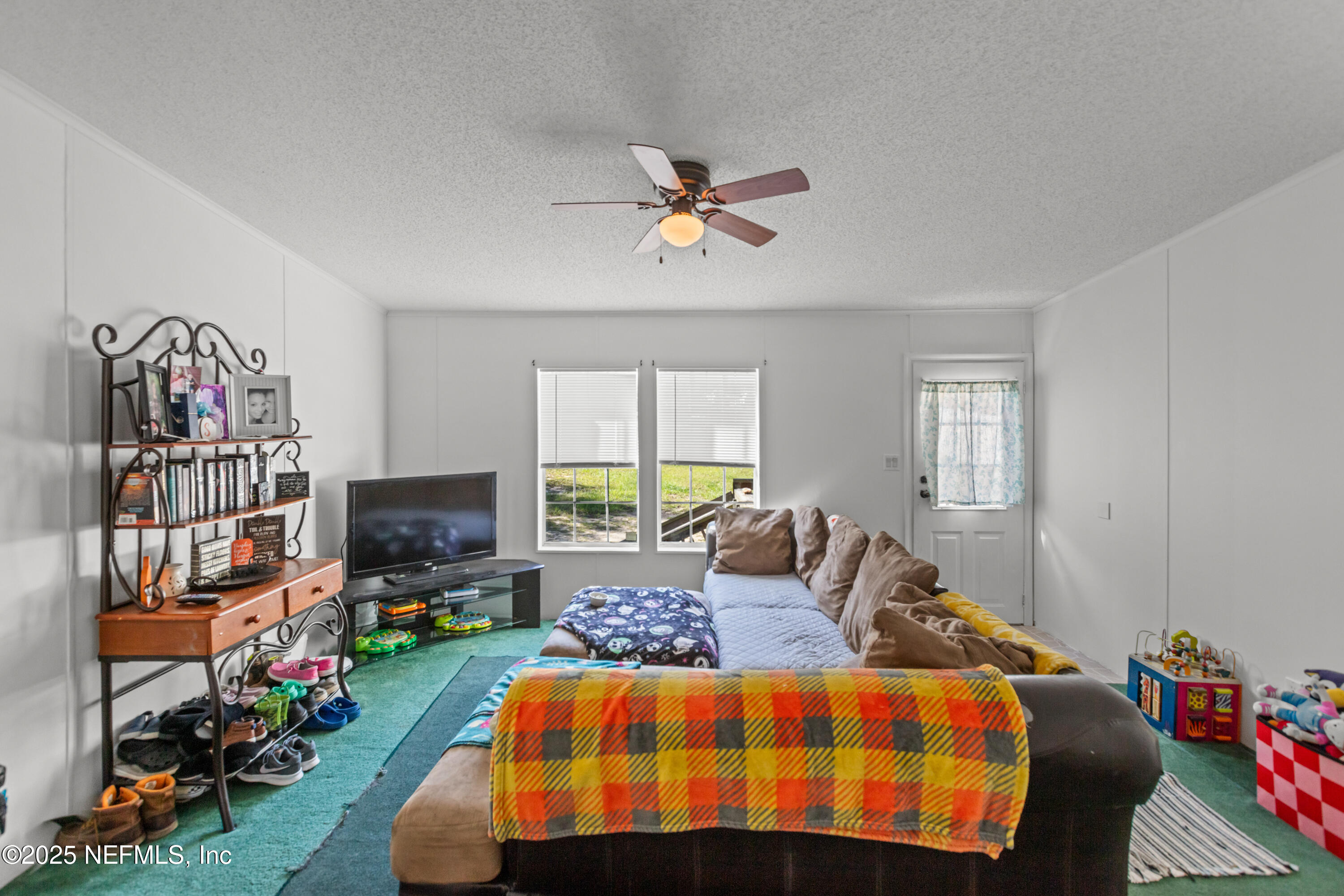 6279 Little Lake Geneva Road Keystone Heights, FL 32656 - Photo 10 of 45 a bedroom with a bed a flat screen tv and a window