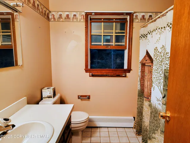 a bathroom with a toilet and a shower curtain