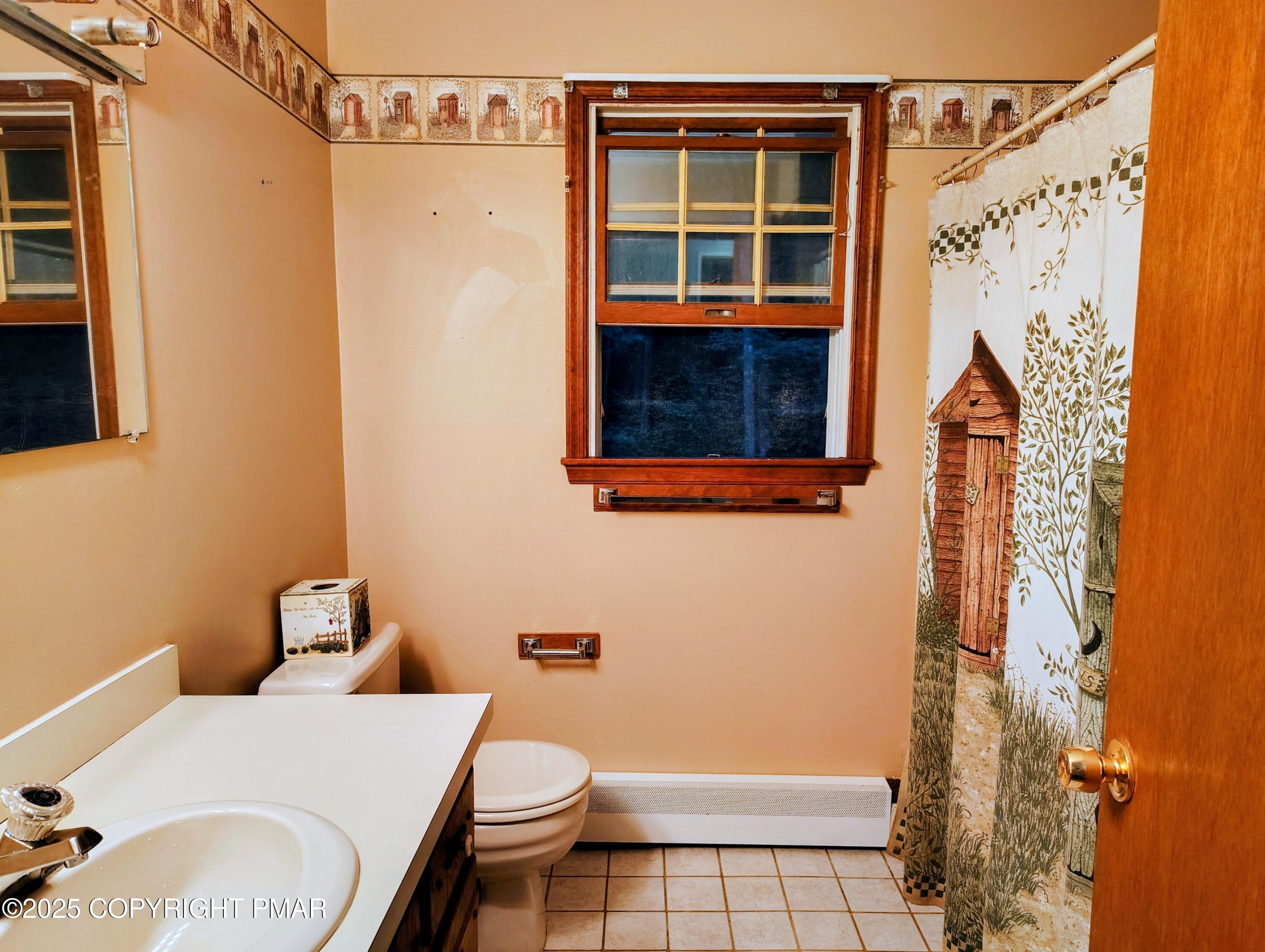 587 Long Mountain Road Effort, PA 18330 - Photo 14 of 29 a bathroom with a toilet and a shower curtain