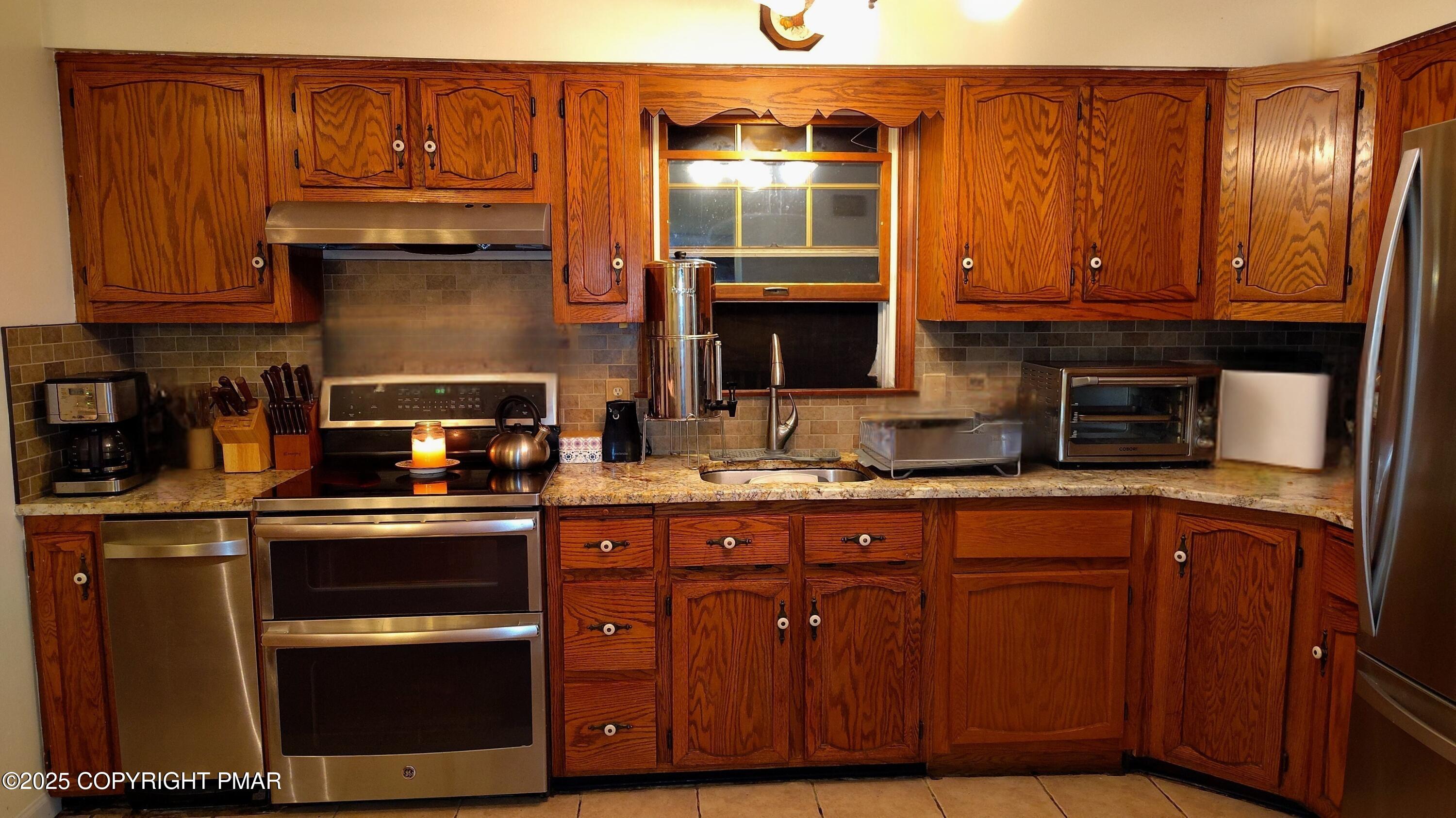 587 Long Mountain Road Effort, PA 18330 - Photo 5 of 29 a kitchen with stainless steel appliances granite countertop wooden cabinets and a stove top oven