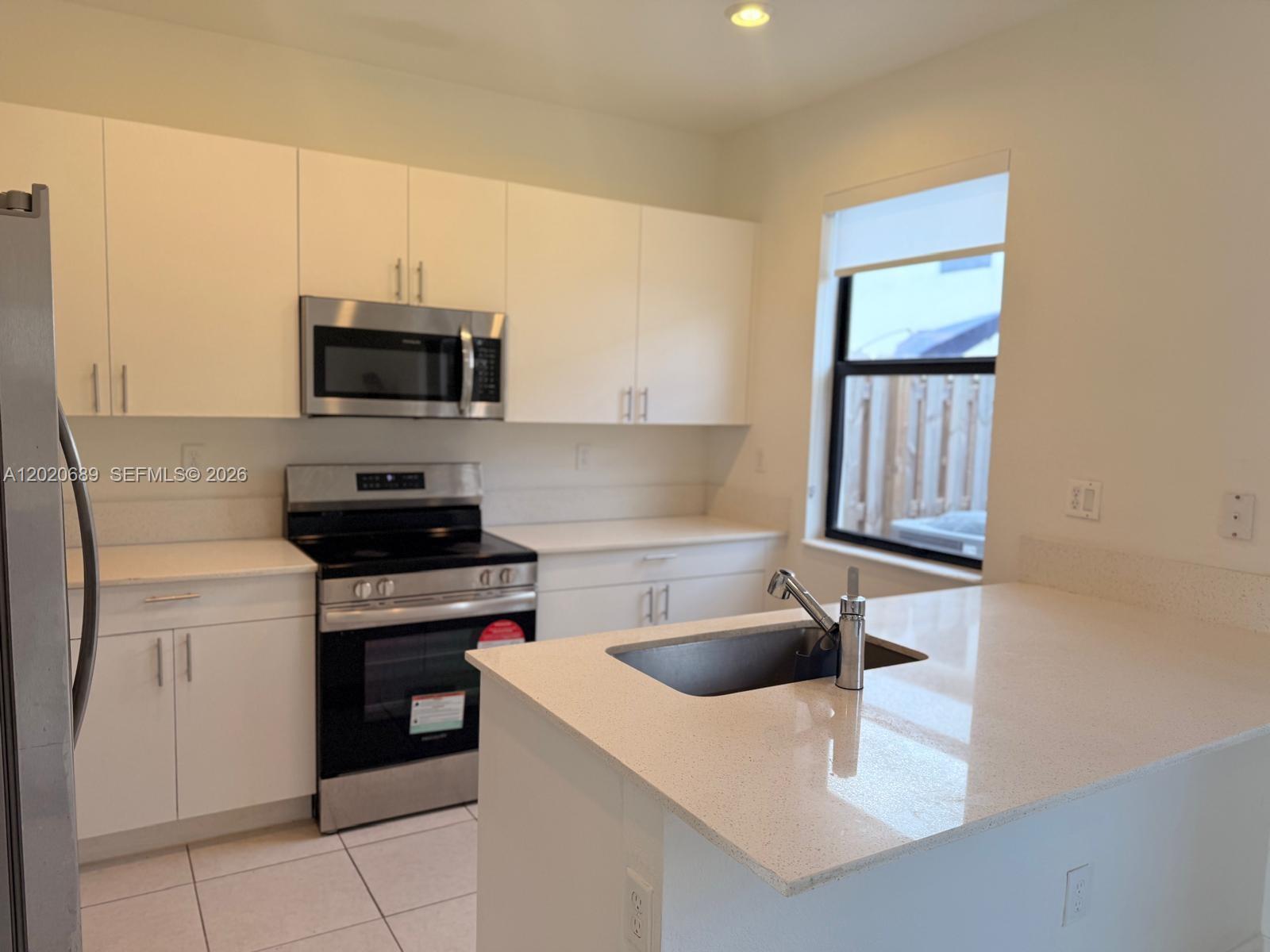 12875 Southwest 231st Terrace Miami, FL 33170 - Photo 8 of 25 a kitchen with a sink a stove and microwave