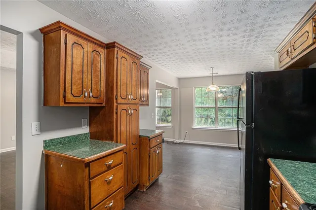 a kitchen with stainless steel appliances granite countertop a stove a refrigerator and a more cabinets