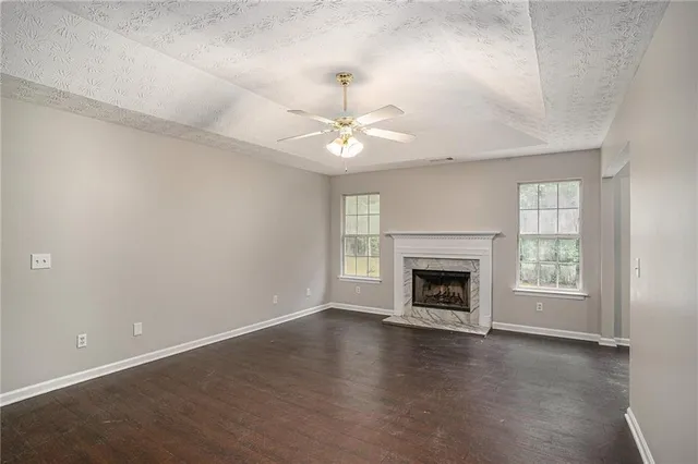 an empty room with windows and fireplace