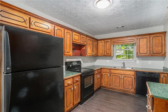 a kitchen with a sink appliances and cabinets