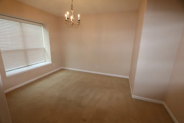 en empty room with windows and chandelier