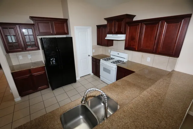 a kitchen with stainless steel appliances wooden cabinets a stove a microwave and a sink
