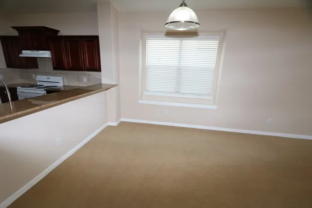 an empty room with a window and wooden floor