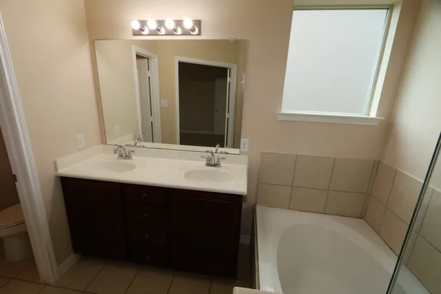 an empty room with a chandelier fan and a window