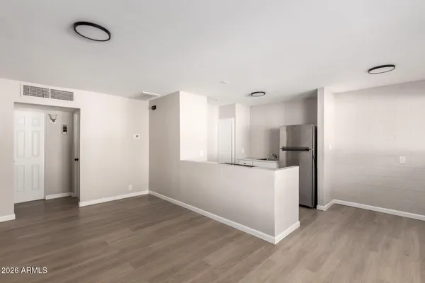 a view of a kitchen with wooden floor and an empty room
