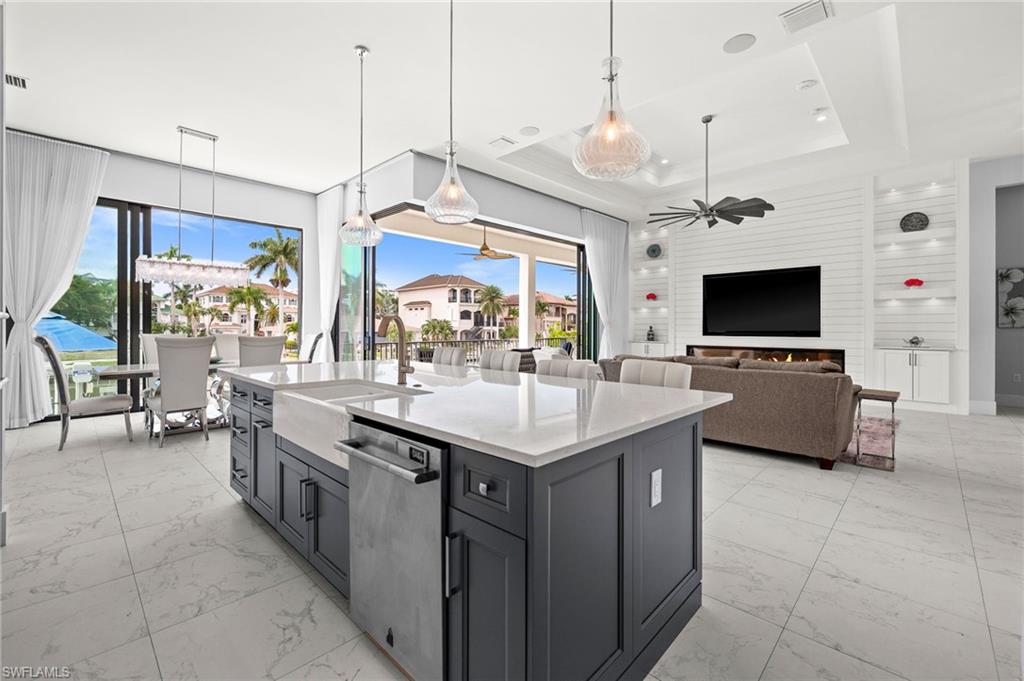 388 Pine Avenue Naples, FL 34108 - Photo 14 of 34 a kitchen with stainless steel appliances kitchen island granite countertop a sink and a flat screen tv