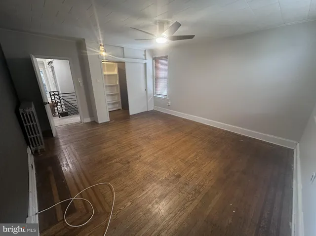 a view of an empty room with window and cabinet