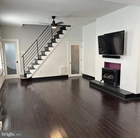 a view of a livingroom with wooden floor and a flat screen tv