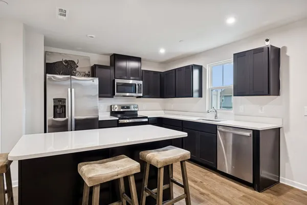 a kitchen with kitchen island a sink counter space and stainless steel appliances