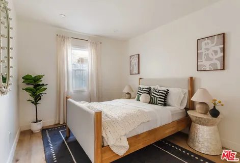 a bedroom with a bed and a potted plant