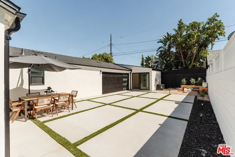 a view of a patio with dining table and chairs with wooden floor