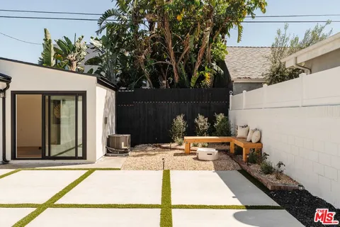 a view of a patio with table and chairs with wooden fence and plants