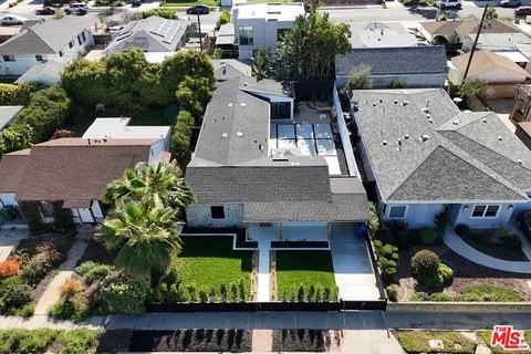 an aerial view of a house with swimming pool and a yard