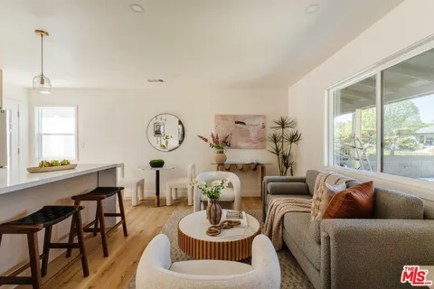 a living room with furniture a window and a large mirror