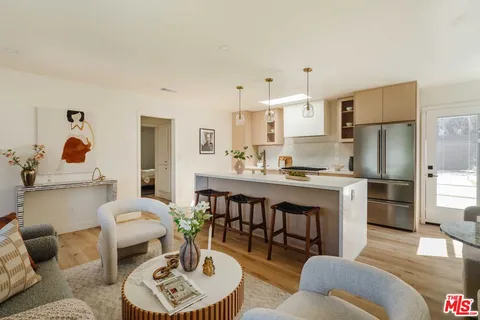 a living room with furniture kitchen view and a refrigerator