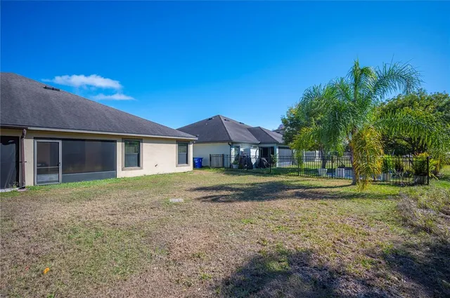 a view of swimming pool with lawn chairs and plants