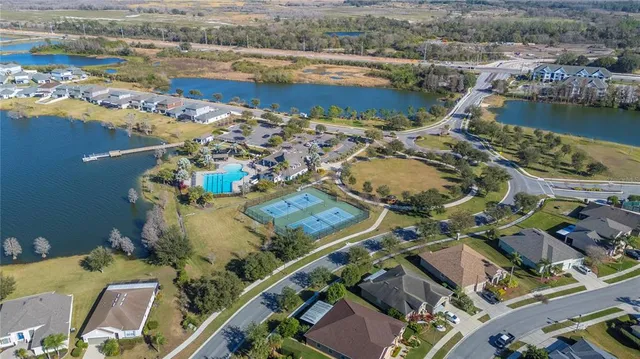 an aerial view of residential houses with outdoor space and lake view