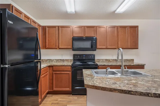 a kitchen with a sink cabinets and wooden floor