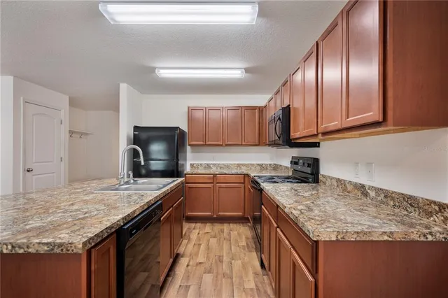 a kitchen with stainless steel appliances granite countertop a stove a sink dishwasher and a refrigerator