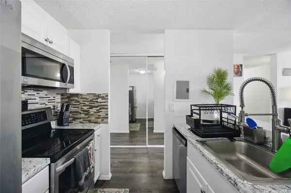 a kitchen with granite countertop a sink stainless steel appliances and cabinets