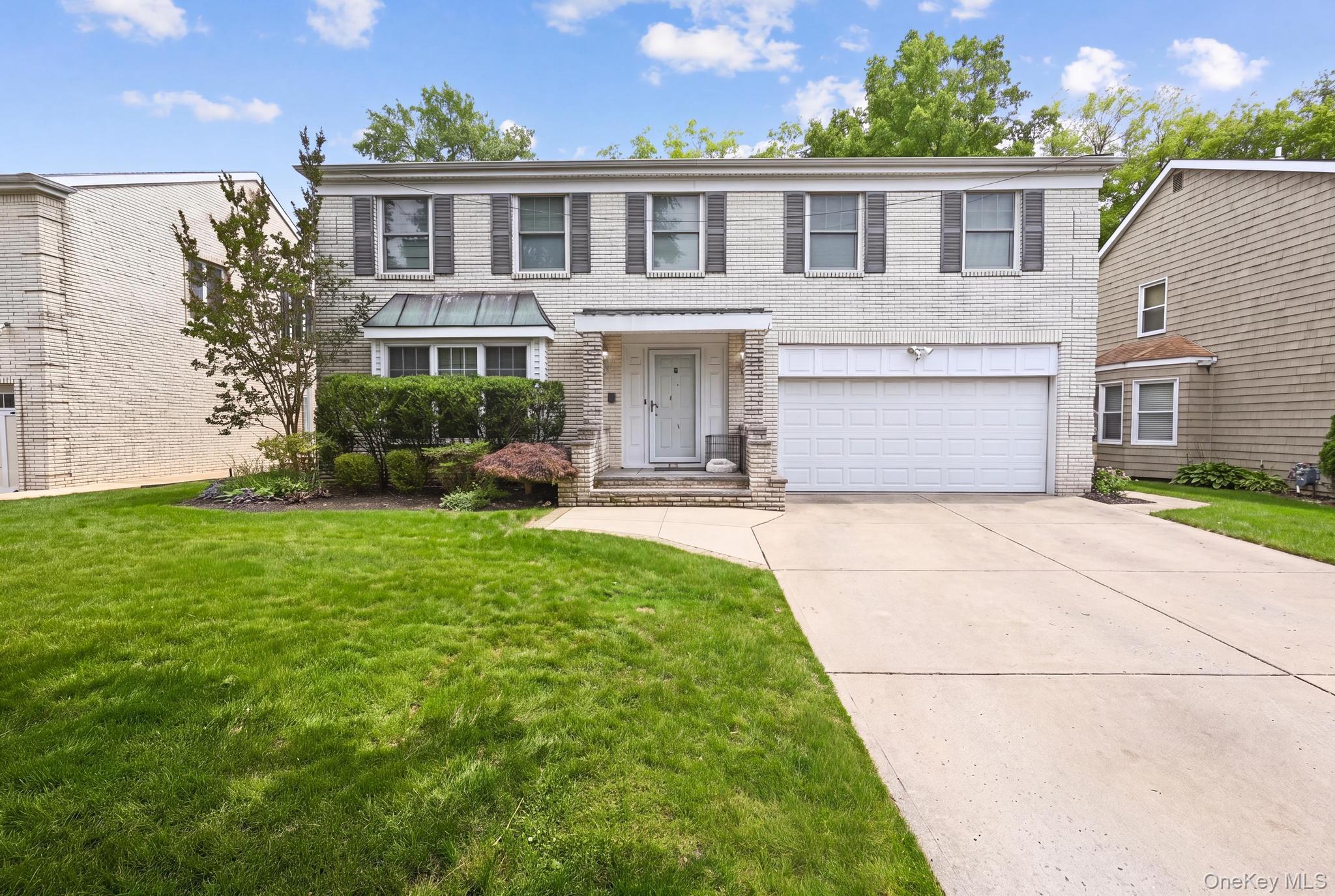 19 Sunset Road West Albertson, NY 11507 - Photo 1 of 24 Traditional two-story residence with a light brick facade and dark window shutters