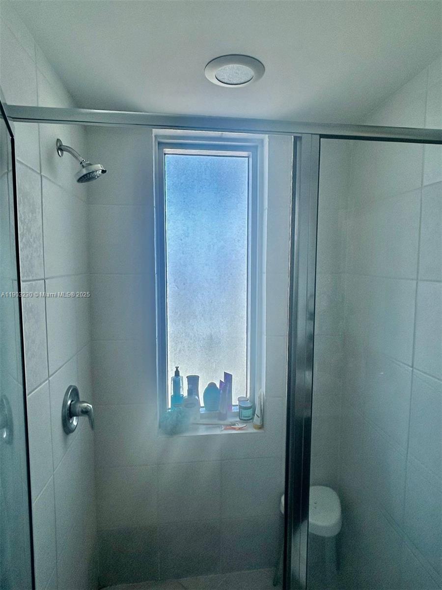 185 Southwest 7th Street, Unit 1802 Miami, FL 33130 - Photo 23 of 39 a bathroom with a glass shower door