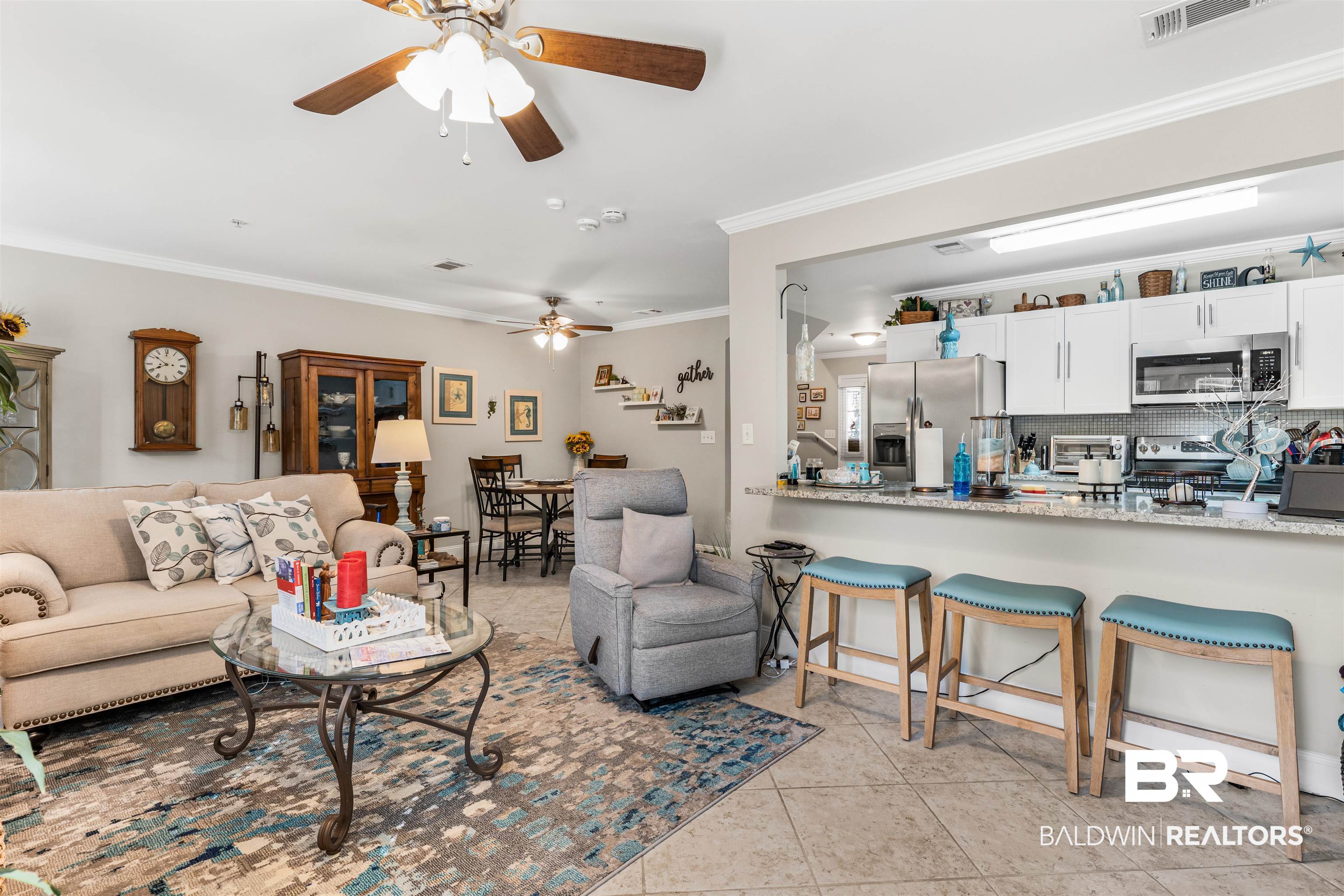 1517 Regency Road, Unit 68 Gulf Shores, AL 36542 - Photo 11 of 43 Living room with crown molding, light tile patterned flooring, and ceiling fan