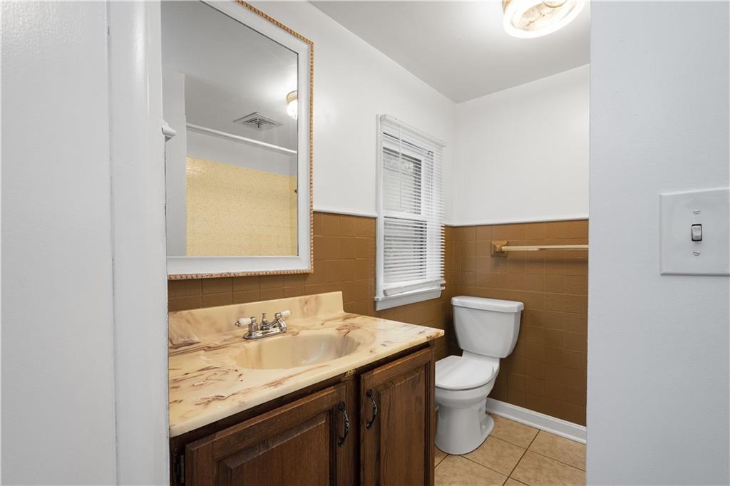 401 Upper Road Pittsburgh, PA 15228 - Photo 23 of 32 a bathroom with a granite countertop sink toilet and mirror