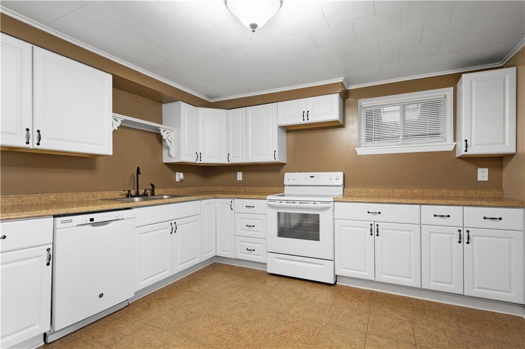 401 Upper Road Pittsburgh, PA 15228 - Photo 9 of 32 a kitchen with granite countertop white cabinets and white appliances