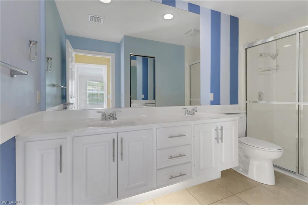 7933 Umberto Court Naples, FL 34114 - Photo 10 of 17 a bathroom with a double vanity sink and a mirror