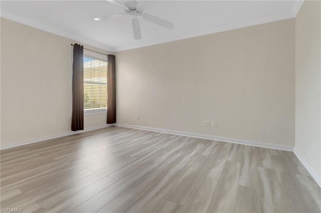 7933 Umberto Court Naples, FL 34114 - Photo 11 of 17 wooden floor in an empty room with a window